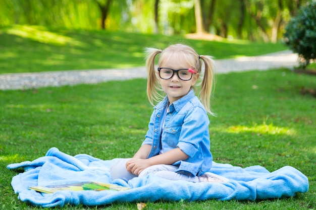A Pretty Little Blonde Girl With Blonde Hair And Reading Glasses