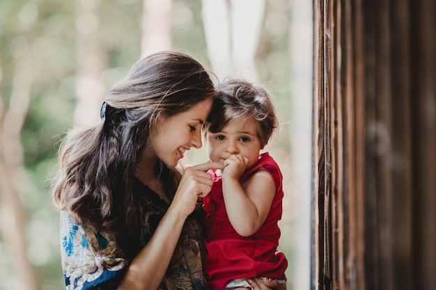 Pretty little child holds mother's finger sitting on her arms Free Photo Pretty little child holds mother's finger sitting on her arms Free Photo