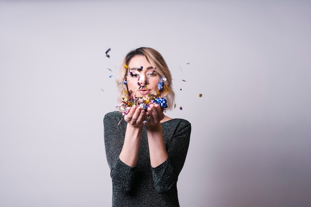 Free Photo | Pretty woman blowing confetti