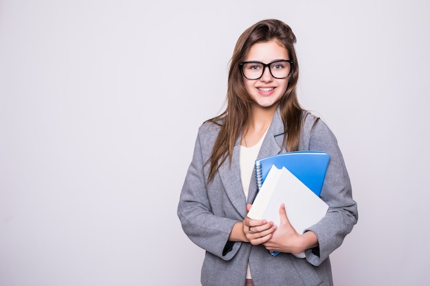 Pretty and young student with big glasses near some books smiling on white background Free Photo
