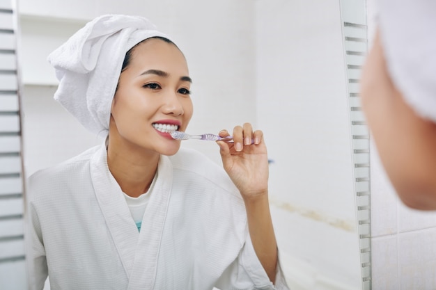 Premium Photo | Pretty young vietnamese woman brushing teeth after ...