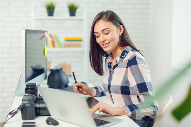 Premium Photo | Pretty young woman photographer with camera in office