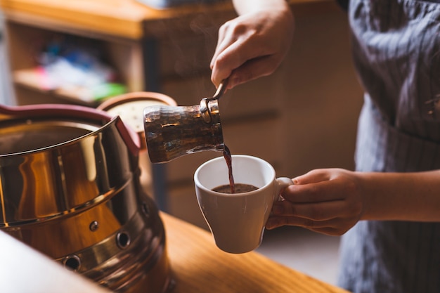 カフェテリアで伝統的なトルコ式コーヒーを提供するプロのバリスタ プレミアム写真