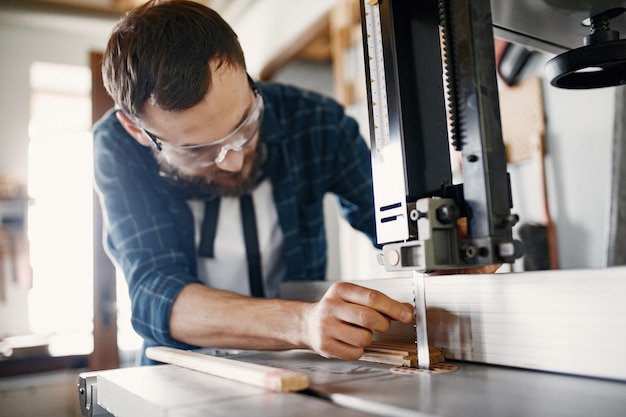 Professional carpenter working with sawing machine Free Photo