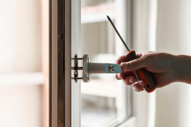 Premium Photo | Professional handyman fixing window handle at home ...