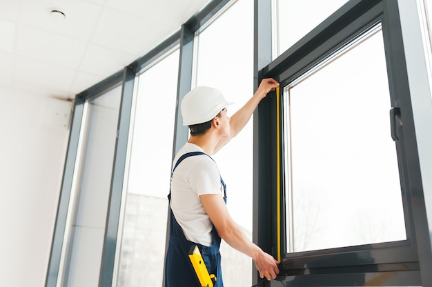 Premium Photo Professional Handyman Installing Window At Home