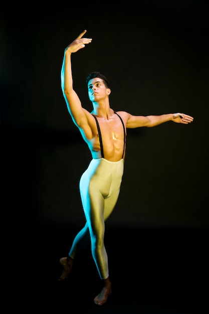 スポットライトで実行するプロの男性バレエダンサー 無料の写真