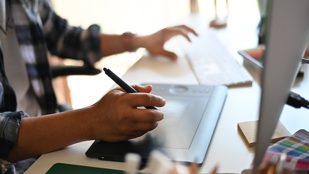 Premium Photo | Professional male freelancer drawing on tablet during ...