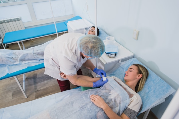 Premium Photo Professional Nurse Making An Injection To A Woman Lying On Operating Table