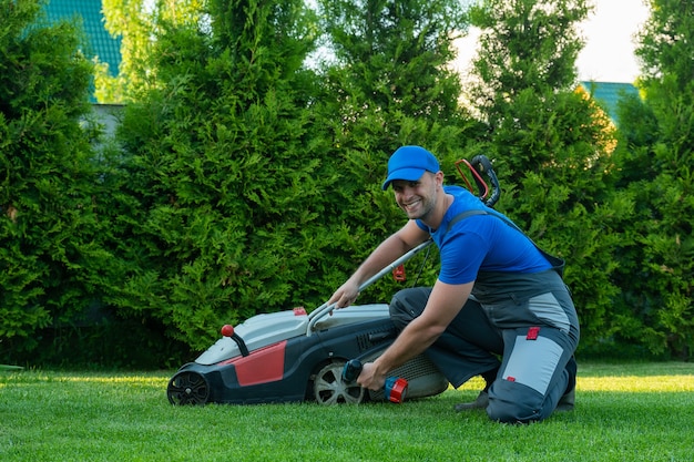 Premium Photo | A professional repairman repairs a lawn mower a man ...