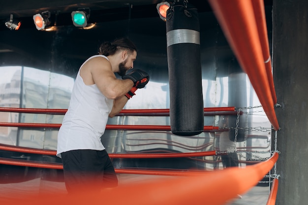 Premium Photo | Professional young boxer in the ring, practice the ...