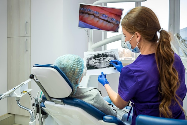 Premium Photo | A promising dentist in a private clinic takes and shows ...