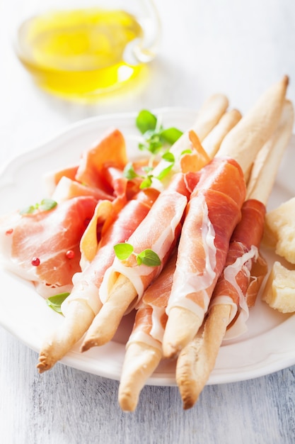 Premium Photo | Prosciutto ham and grissini bread sticks. italian antipasto