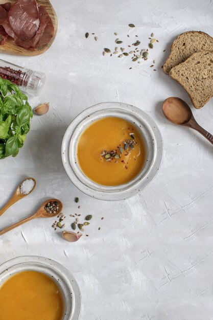 Pumpkin soup plate top view, gray background, copy space. Premium Photo