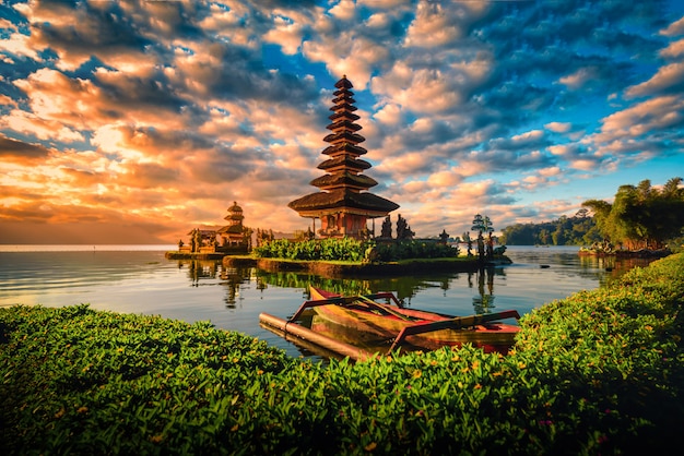 Pura ulun danu bratan, hindu temple with boat on bratan lake landscape at sunrise in bali, indonesia. Premium Photo