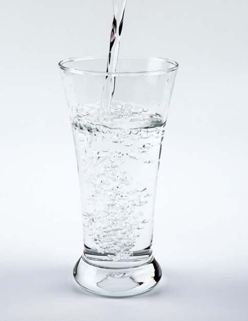 Premium Photo | Puring water into glass on whtie background