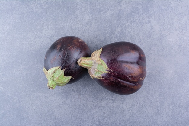 Purple eggplants isolated on blue surface Free Photo