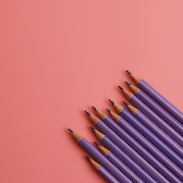 Premium Photo | Purple pencils on pink background with copy space