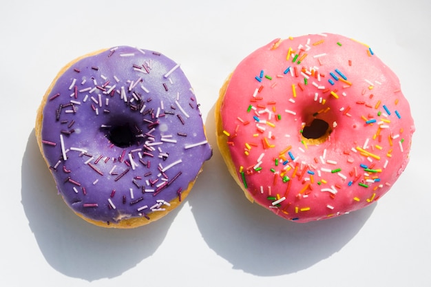 Free Photo | Purple and pink donuts on white background