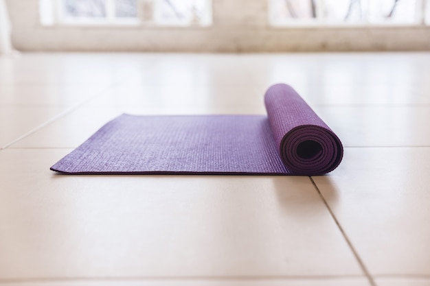 Premium Photo | Purple yoga mat lying on the light floor