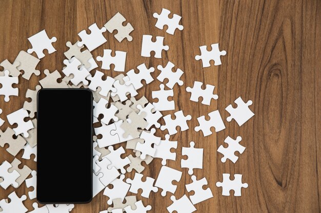 Puzzle Pieces And Smartphone On Wooden Table Photo Free