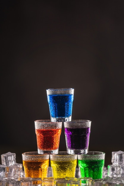 Premium Photo | Pyramid of shots with colorful alcohol on ice