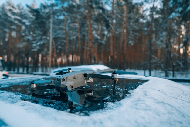 雪に覆われた車の屋根の上に立っているquadrocopter 無料の写真