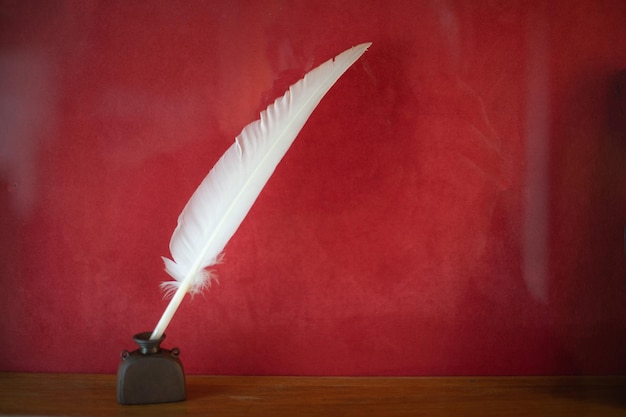 Premium Photo | Quill pen with inkwell on wooden desk vintage old style