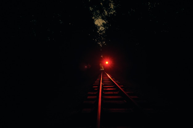 Premium Photo | Railroad track at night. red light is on.