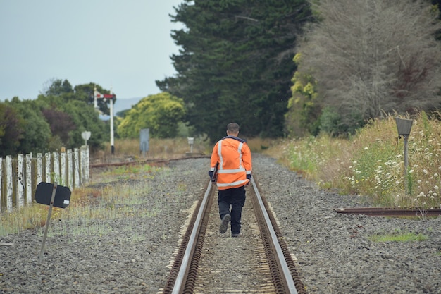 線路の間を歩いている鉄道労働者 無料の写真