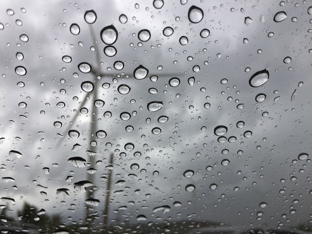 車のガラスに雨が降る外は風車の景色です 悲しい 孤独な背景 プレミアム写真