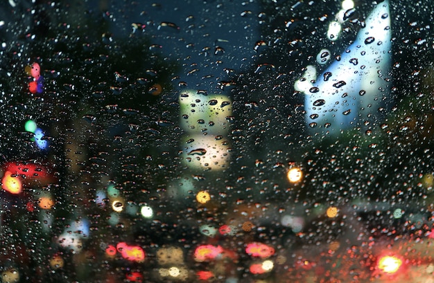 Premium Photo | Raindrops on the car windshield with blurred traffic ...