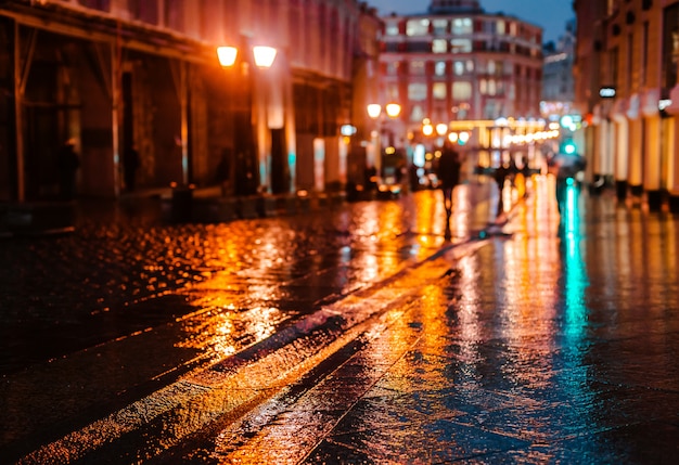 Rainy night in a big city, reflections of lights on the wet road ...