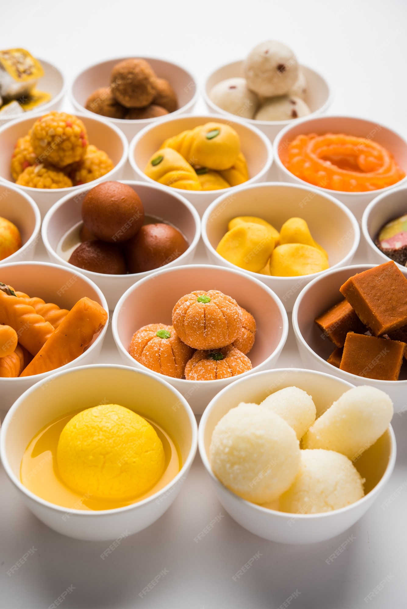 Premium Photo | Rangoli of assorted indian sweets or mithai in bowl for ...