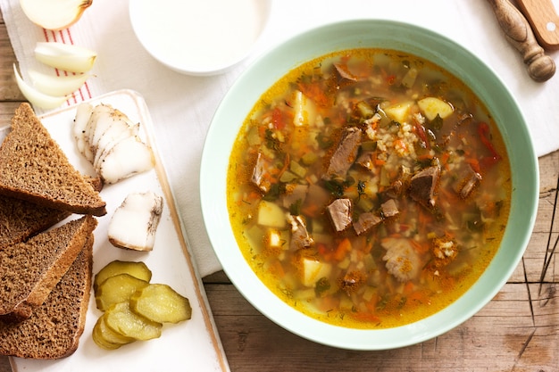 Rassolnik, traditional russian soup, served with various snacks and vodka. Premium Photo