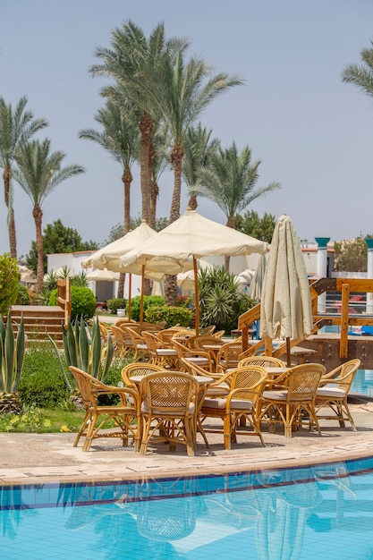 Premium Photo | Rattan table and chairs in beach cafe near swimming pool