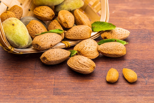 Raw almonds, peeled, with peel, skin (almendrucos) and almond leaves. Premium Photo