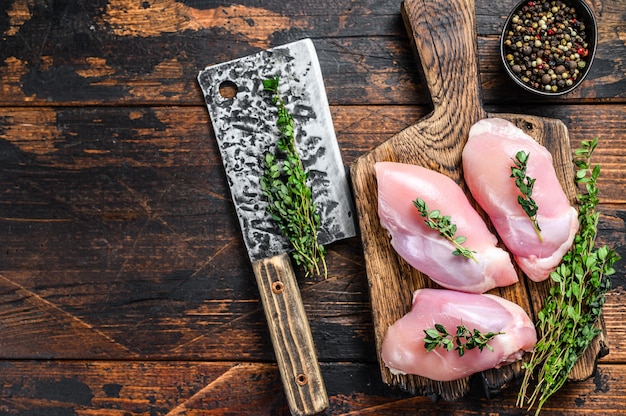 Premium Photo | Raw chicken skinless thigh fillet on a wooden cutting ...