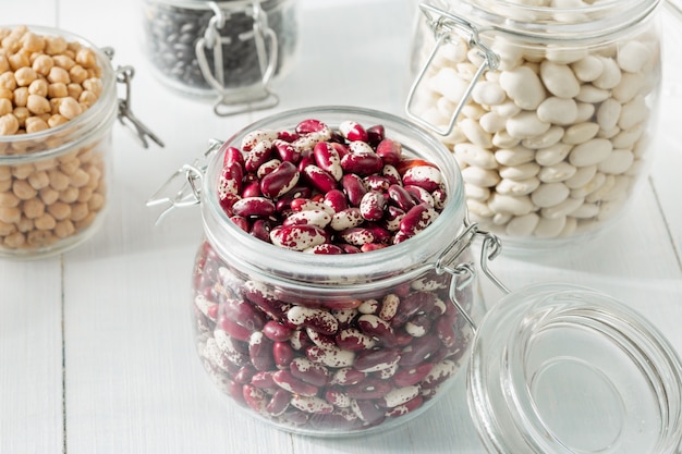 Premium Photo | Raw different bean in a glass jar closeup