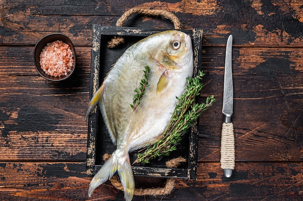 Premium Photo | Raw fish butterfish or pompano with herbs in a wooden ...