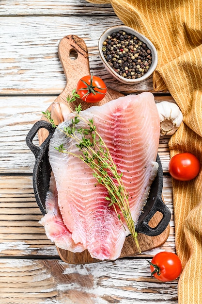 Premium Photo | Raw fish telapiya in a pan. white wooden background ...
