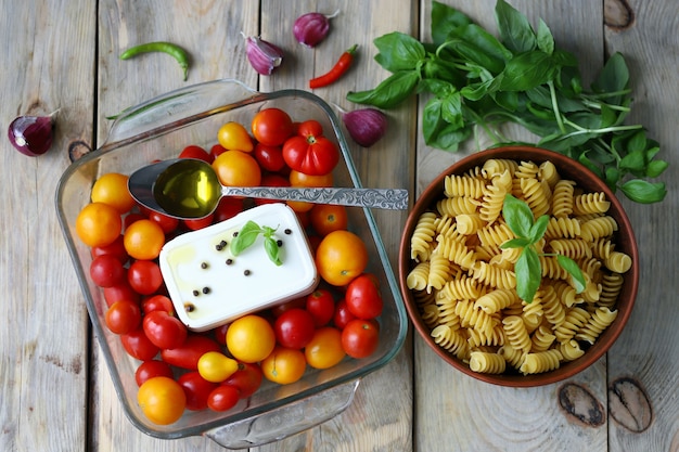 Premium Photo | Raw pasta feta and cherry tomatoes in a glass form