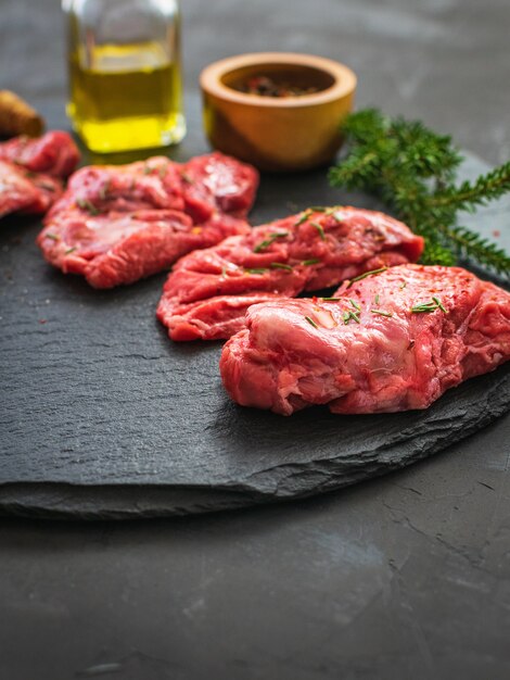 premium-photo-raw-pork-cheeks-meat-on-a-dark-gray-surface-with