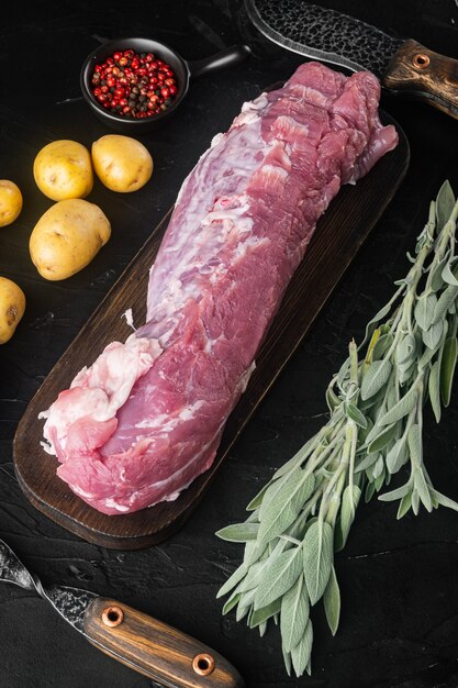 Premium Photo Raw Pork Fillet With Sage Set On Wooden Cutting Board With Barbeque Knife And Meat Fork On Black Stone Table Top View Flat Lay