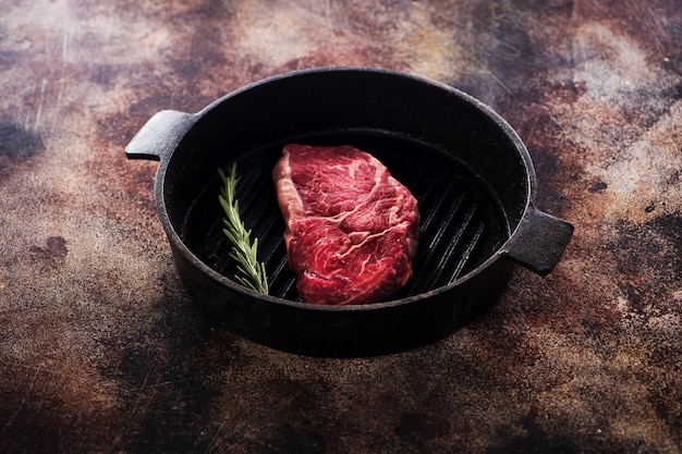 Premium Photo Raw Ribeye Steak On A Cast Iron Pan With Rosemary 