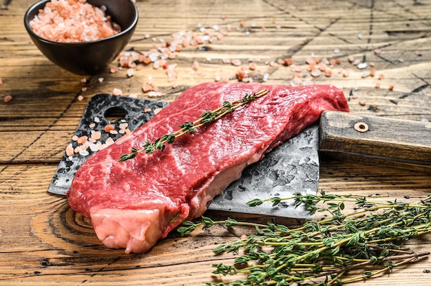 Premium Photo Raw Striploin Steak On A Meat Cleaver Marbled Beef Wooden Background Top View