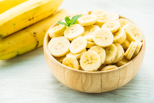 Raw yellow banana slices in wooden bowl Free Photo