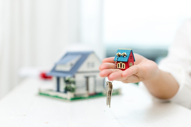 Real estate agent with house model and keys Free Photo