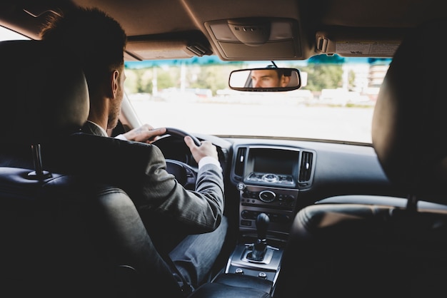 Rear view of businessman driving the car Photo | Free Download