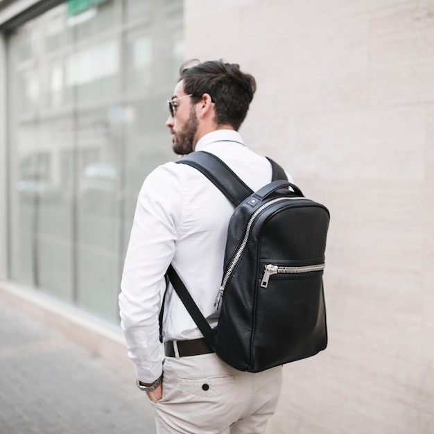 Free Photo | Rear view of a male tourist with black backpack
